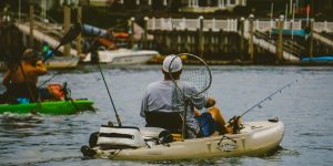 man in black jacket riding yellow and white personal watercraft on water during daytime